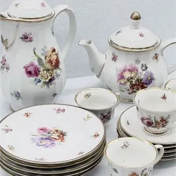 Sale Photo Thumbnail #7: Vintage fine porcelain tea set featuring hand-painted floral motifs and gilt trim, including a coffee pot, teapot, teacups, and stacked saucers and plates.