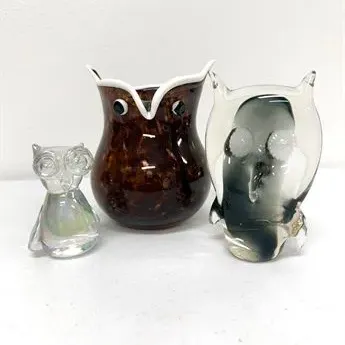 Sale Photo Thumbnail #59: Trio of vintage glass owl figurines and a vessel, including a small clear glass owl, a tortoiseshell-patterned blown glass owl vase, and a solid smoky glass owl paperweight.