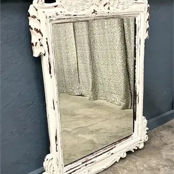 Sale Photo Thumbnail #27: French provincial style wall mirror featuring a heavily distressed white painted frame with intricate shell cresting and scrollwork details.