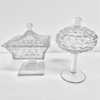 Sale Photo Thumbnail #55: Pair of vintage clear pressed glass pedestal candy dishes with matching lids, featuring square and round diamond-cut patterns.
