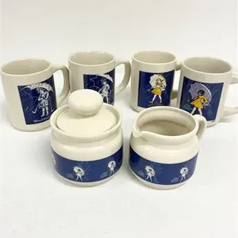 Sale Photo Thumbnail #3: Six-piece Morton Salt ceramic set, including four coffee mugs, a lidded sugar bowl, and a creamer jug, featuring blue umbrella girl illustrations.