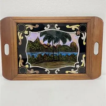Sale Photo Thumbnail #54: Vintage Brazilian wooden serving tray featuring a reverse-painted glass inlay with iridescent butterfly wing art depicting a tropical landscape with palm trees.