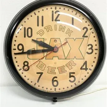 Sale Photo Thumbnail #68: Vintage mid-century Drink Jax Beer round wall clock by General Electric, featuring a black frame and aged graphic face.