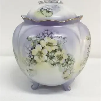Sale Photo Thumbnail #41: Antique hand-painted porcelain covered jar with feet, decorated with yellow and purple flowers on a lavender gradient background and trimmed in gold.