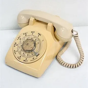 Sale Photo Thumbnail #50: Vintage beige Western Electric Model 500 rotary dial landline telephone with coiled handset cord.