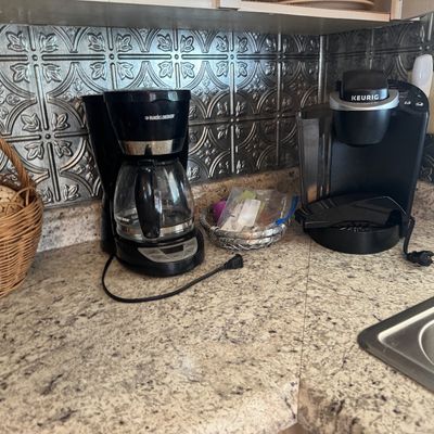 Black & Decker 12-cup drip coffee maker alongside a black Keurig single-serve K-Cup coffee brewer on a kitchen countertop.