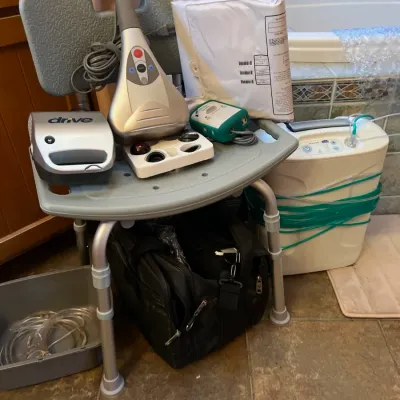 Sale Photo Thumbnail #26: Assortment of medical equipment including a shower chair, Drive Medical nebulizer, handheld massager, and oxygen concentrator.