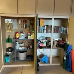 Sale Photo Thumbnail #38: Built-in wooden garage storage cabinets containing hand tools, garden supplies, books, household goods, and folding chairs.