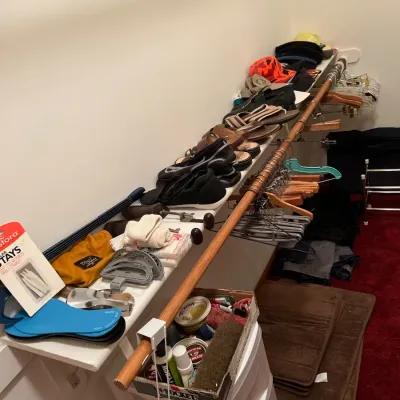 Sale Photo Thumbnail #30: Closet shelf filled with assorted men's footwear, hats, shoe accessories, and clothes hangers.