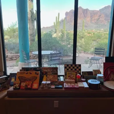 Sale Photo Thumbnail #4: Selection of vintage board games, puzzles, and playing cards displayed on a window bench overlooking a desert mountain landscape.