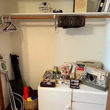 Sale Photo Thumbnail #13: A vintage Singer sewing machine with hardshell case, sewing supplies, craft materials, floor magnifying lamp, and books arranged in a closet storage setup.