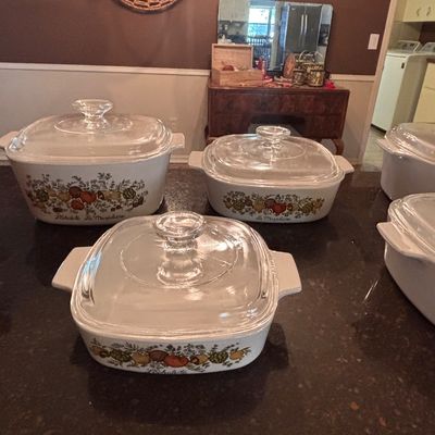 Sale Photo Thumbnail #131: Vintage Corning Ware Spice O' Life pattern casserole dishes with clear glass Pyrex lids, displayed on a countertop.