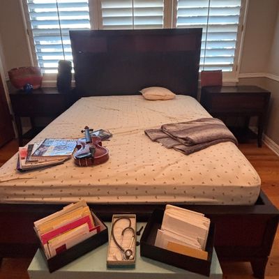 Sale Photo Thumbnail #87: Modern dark wood platform bed frame with matching nightstands, featuring a violin, magazines, and various office items displayed on and near the mattress.