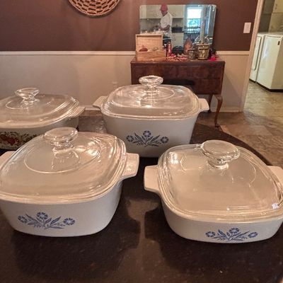 Sale Photo Thumbnail #132: Collection of vintage CorningWare casseroles with clear glass lids, featuring classic Cornflower Blue and Spice O' Life patterns.