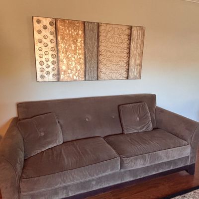Sale Photo Thumbnail #153: Contemporary taupe velvet sofa with matching accent pillows beneath a large multi-paneled abstract canvas wall art.