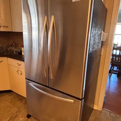 Sale Photo Thumbnail #144: Whirlpool stainless steel French door refrigerator with a bottom freezer drawer.