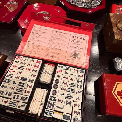 Sale Photo Thumbnail #107: Vintage Japanese mahjong set in a red vinyl carrying case with instructional inserts, displayed alongside various mother-of-pearl inlaid lacquer boxes.