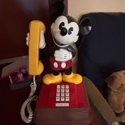Sale Photo Thumbnail #75: Vintage ATC Mickey Mouse novelty push-button landline telephone featuring a faux-wood grain base and yellow handset, circa 1970s.