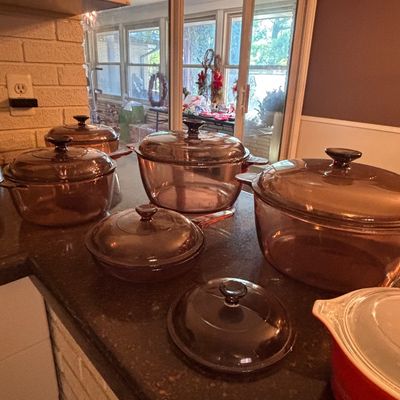 Sale Photo Thumbnail #129: Vintage Amber Visions amber glass cookware set with matching lids, displayed on a kitchen counter.