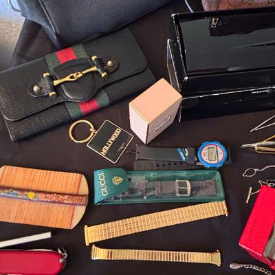 Sale Photo Thumbnail #158: Collection of assorted vintage accessories, featuring a Gucci Web stripe horsebit wallet, wristwatches, watch bands, pocket knives, and a Hollywood keychain.