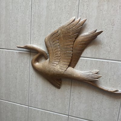 Sale Photo Thumbnail #44: Hand-carved wooden wall sculpture depicting a crane or heron in flight, featuring detailed feather textures.