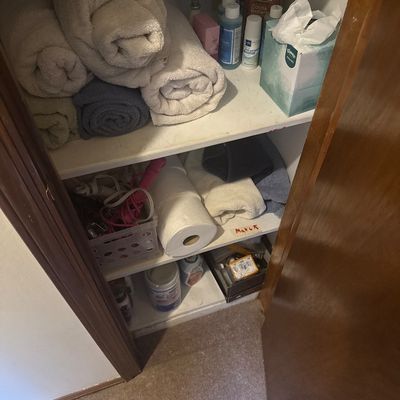 Sale Photo Thumbnail #41: Linen closet filled with assorted bath towels, toiletries, paper products, and household cleaning supplies.