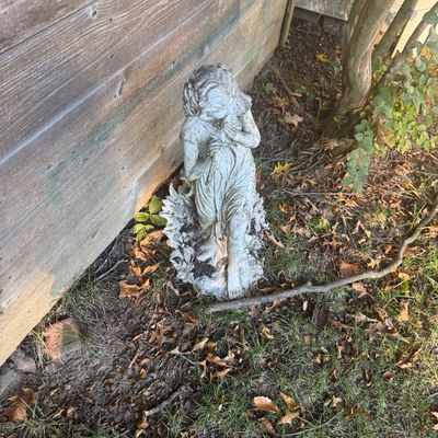 Sale Photo Thumbnail #130: Weathered concrete garden statue depicting a young girl holding flowers, featuring light distress and moss patina from outdoor use.