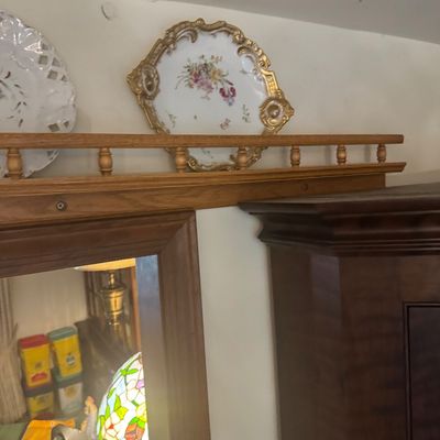 Sale Photo Thumbnail #204: Vintage floral porcelain serveware tray with heavily gilded, ornate handles and rim displayed on top of a wooden shelf.