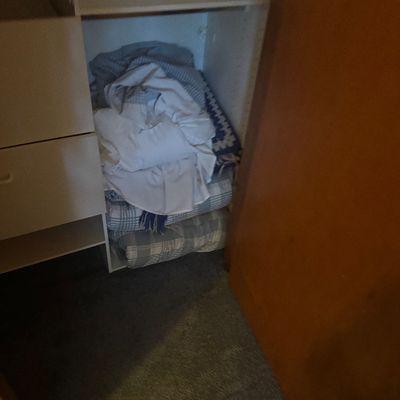 Sale Photo Thumbnail #50: Assorted household linens, blankets, and bedding stacked inside a wooden closet shelf unit.