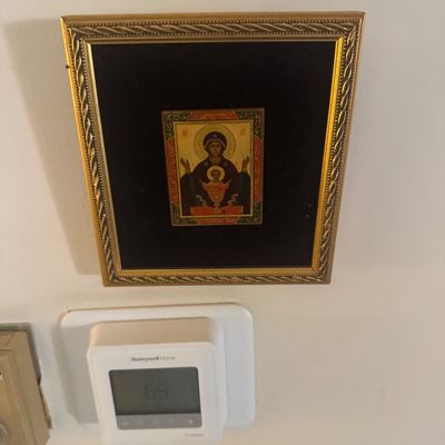Sale Photo Thumbnail #143: Framed Russian Orthodox icon miniature depicting the Virgin Mary and Child, set against a black velvet mat in an ornate gold-tone frame.