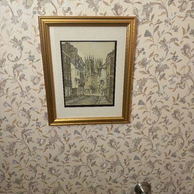 Sale Photo Thumbnail #77: Framed architectural sketch depicting a European city street leading to a cathedral, set in a metallic gold-finished frame with cream matting.