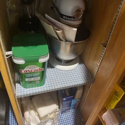 Sale Photo Thumbnail #242: White KitchenAid stand mixer with stainless steel bowl, alongside a blender and household supplies inside a pantry cabinet.