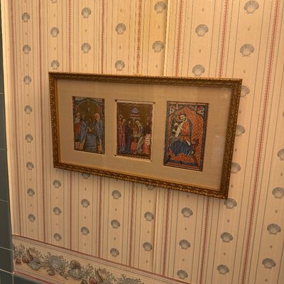 Sale Photo Thumbnail #14: Framed set of three medieval-style illuminated manuscript leaf reproductions, presented in an ornate gilt wood frame with a cream mat.