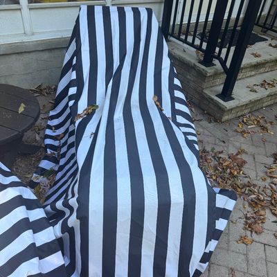 Sale Photo Thumbnail #134: Outdoor chaise lounge protected by a black-and-white striped waterproof fabric cover.