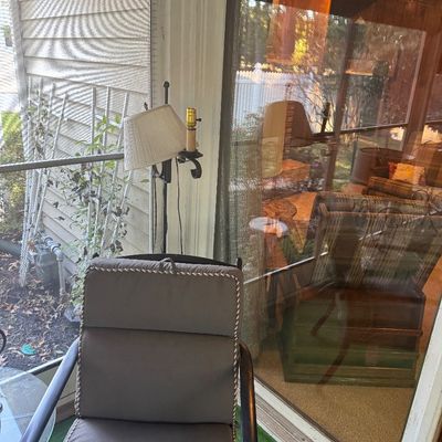 Sale Photo Thumbnail #5: Outdoor patio chair with gray seat cushions, positioned near a tall metal floor lamp on a sunporch.