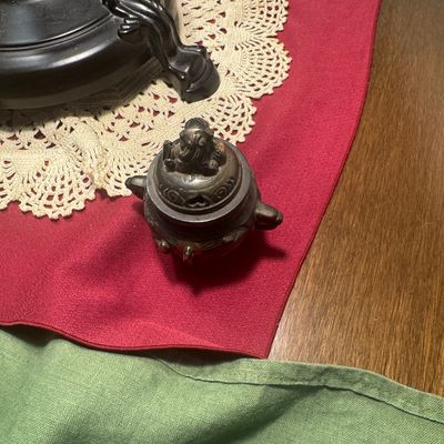 Sale Photo Thumbnail #188: Small Asian-style dark bronze censer featuring dual handles and a pierced lid topped with a foo dog finial.