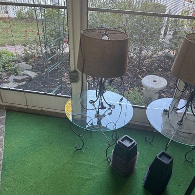 Sale Photo Thumbnail #7: Pair of wrought iron table lamps with burlap drum shades, accompanied by matching round glass-top side tables with scrollwork frames.
