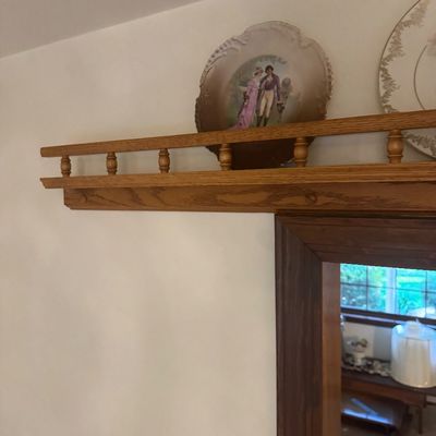 Sale Photo Thumbnail #201: Wall-mounted oak plate rail shelf featuring spindle gallery detailing, displayed with decorative ceramic plates.