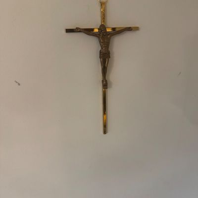 Sale Photo Thumbnail #200: Wall-mounted brass crucifix featuring a molded figure of Jesus on a polished cross.