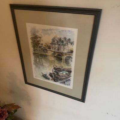 Sale Photo Thumbnail #145: Framed watercolor print depicting a European riverside scene with a bridge and buildings, set in a dark wood frame with matting.