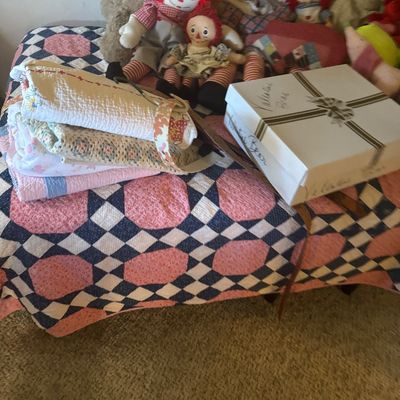 Sale Photo Thumbnail #62: Collection of vintage plush dolls, Raggedy Ann and Andy figures, and folded handmade quilts arranged on a bed.