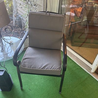 Sale Photo Thumbnail #6: Black wrought iron outdoor armchair fitted with a thick grey cushion trimmed in braided piping.