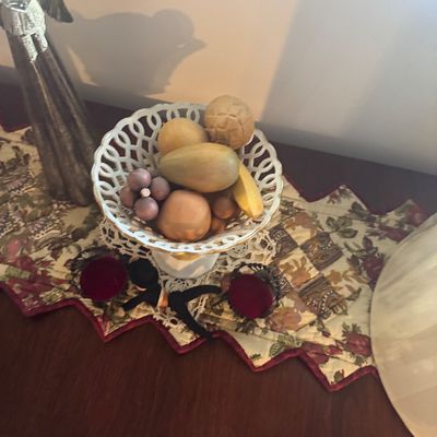 Sale Photo Thumbnail #184: Vintage reticulated porcelain footed bowl filled with carved wooden decorative fruit, displayed on a quilted table runner.