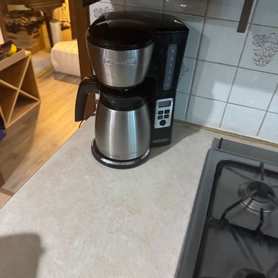 Sale Photo Thumbnail #238: Black + Decker modern drip coffee maker with a stainless steel thermal carafe, sitting on a kitchen countertop.