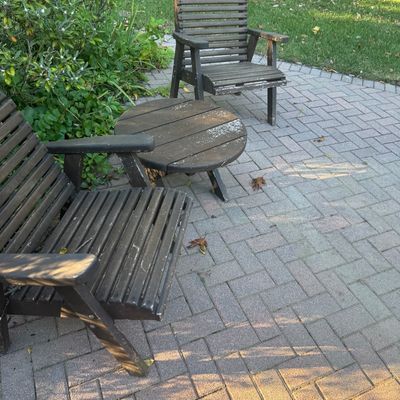 Sale Photo Thumbnail #137: Weathered dark wood patio furniture set including two slat-back armchairs and a small round side table.