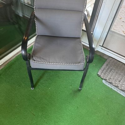 Sale Photo Thumbnail #4: Black metal patio armchair featuring curved armrests and grey fabric seat and back cushions with rope trim.
