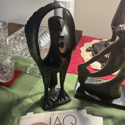 Sale Photo Thumbnail #193: Inuit-style carved stone bird sculpture alongside a soapstone figure sculpture and a copy of Inuit Art Quarterly magazine.
