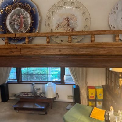 Sale Photo Thumbnail #206: Collection of decorative porcelain display plates with classical scenes, resting on a wooden ledge above a living area.