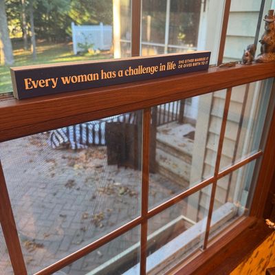 Sale Photo Thumbnail #13: A wooden novelty sign with a humorous quote resting on a windowsill, alongside small squirrel figurines.