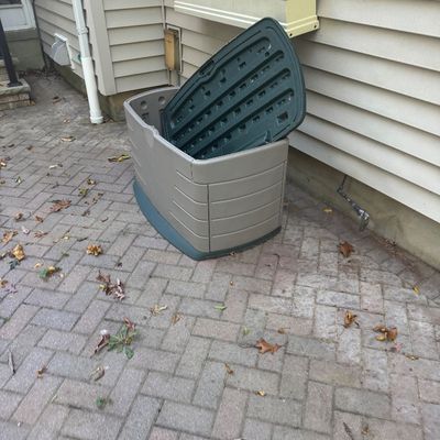 Sale Photo Thumbnail #139: Large outdoor plastic storage bin with a hinged dark green lid, resting on a brick patio.
